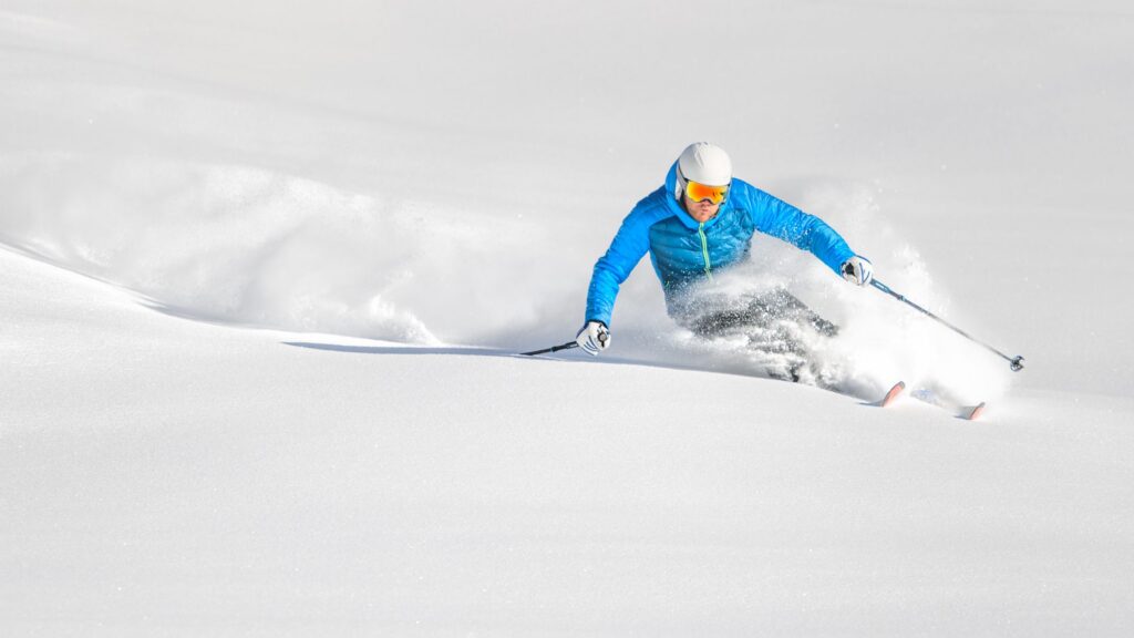 Sciatore in curva sulla neve fresca